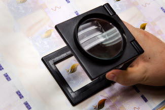Kvalitetskontroll av färgskiftande bild för 1 000-kronorssedeln.